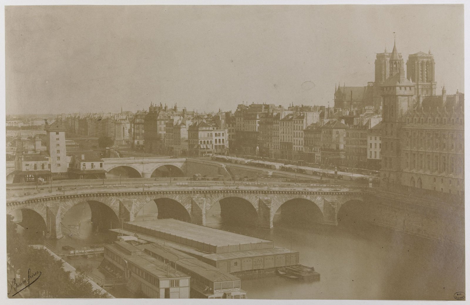 Photographie ancienne du pont au Change et des bâtiments qui bordent la Seine, prise depuis la rive droite